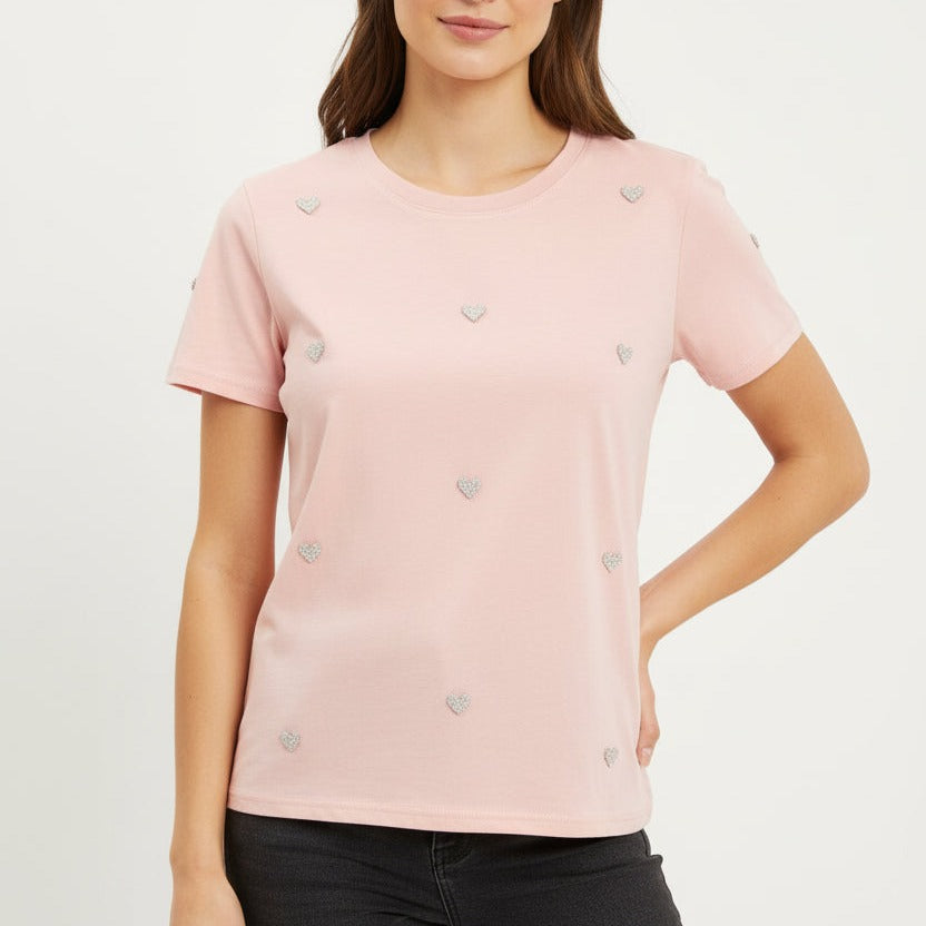 Woman wearing a pink t-shirt with heart patterns on a white background