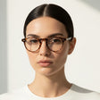 Woman wearing sunglasses against a light background