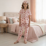 Child wearing pink pajamas with cherry pattern in a bedroom.