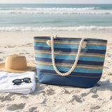 Striped beach bag on a sandy beach with ocean view