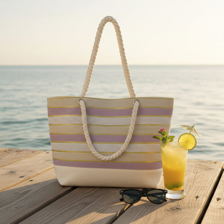 Striped beach bag on a sandy beach with ocean in the background