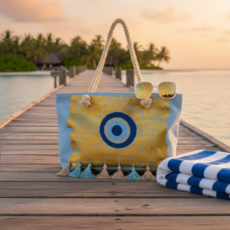 Tote bag with a blue and yellow design on a wooden dock by a body of water.