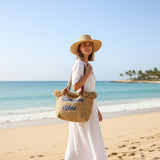 Woman on a beach holding a tote bag with 'Summer Vibes' text