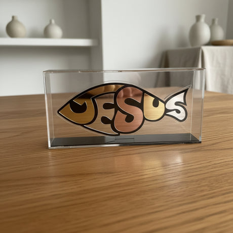 Decorative glass piece with 'Jesus' fish symbol on a white background