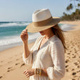 Woman in a white dress and straw hat on a beach