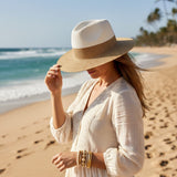Woman in a white dress and straw hat on a beach