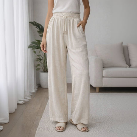 Person wearing beige wide-leg pants in a home setting