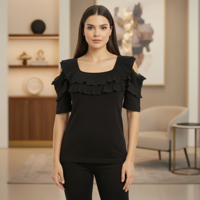 Woman wearing a black ruffled top in an indoor setting