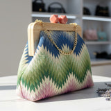 Colorful handbag with wooden frame and chain handle on a surface with blurred background