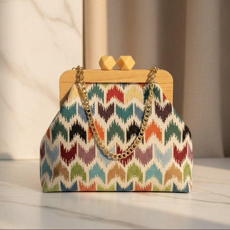 Colorful handbag with a wooden frame and chain handle on a light surface.