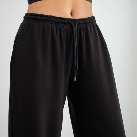 Black wide-leg pants worn by a person on a light gray background