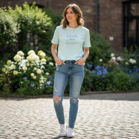 Light blue t-shirt with 'Success is a decision' text on a dark surface