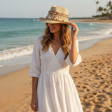 Woman in a white dress and straw hat on a beach
