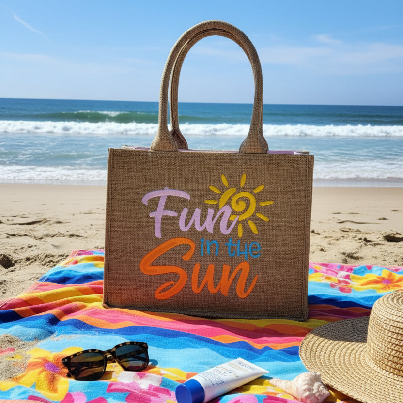 Jute bag with 'Fun in the Sun' text and sun graphic on a wooden surface.