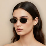Woman wearing round sunglasses with a beige background