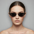 Model wearing black sunglasses with a plain background