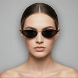 Model wearing black sunglasses with a plain background