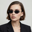 Woman wearing a pair of sunglasses with a plain background