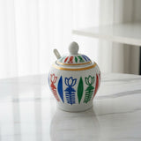 Decorative ceramic jar with colorful floral patterns on a marble surface.