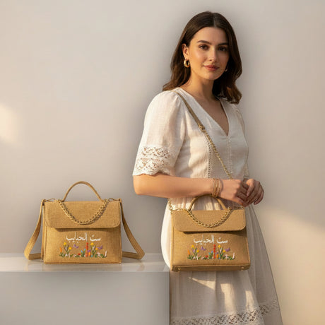 Woman holding a beige handbag with floral embroidery on a light background