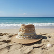Decorative straw hat with embellishments on a plain background