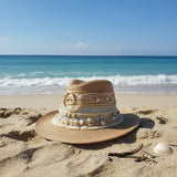 Decorative straw hat with embellishments on a plain background