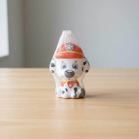 Plush toy dog with a fire helmet in a mesh bag on a cardboard box background