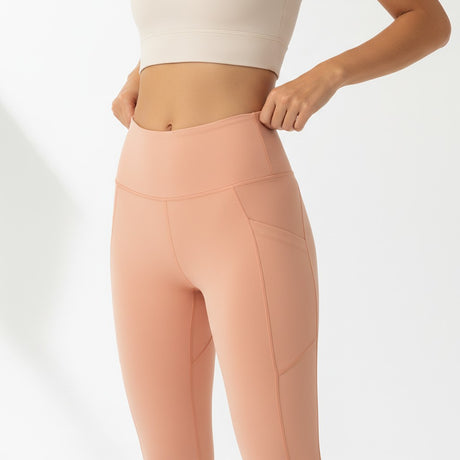 Person wearing peach leggings on a white background