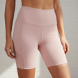 Pink athletic shorts worn by a person on a neutral background