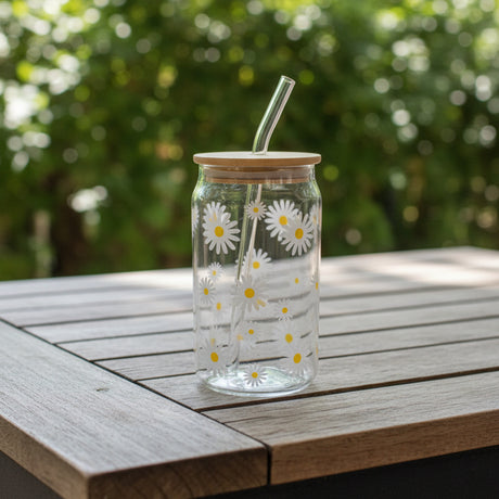 Clear glass with floral design and wooden lid on a wooden surface