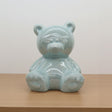 Clear glass bear figurine on a white surface with a blurred store background