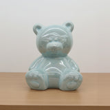 Clear glass bear figurine on a white surface with a blurred store background