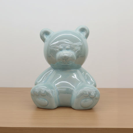 Clear glass bear figurine on a white surface with a blurred store background