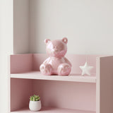 Pink bear-shaped bottle on a counter with a store setting in the background
