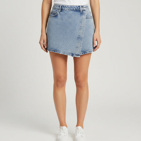 Blue denim shorts on a table with a mirror reflecting clothing in the background