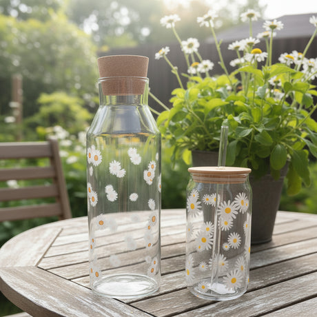 Two glass bottles with floral designs on a pink background