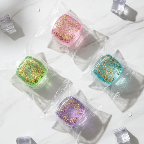 Four colorful items in clear plastic packaging on a dark surface