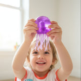 Hand holding a purple jellyfish-shaped object in front of a cardboard box with 'Made in China' text.