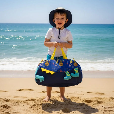 Child holding a beach bag with 'Beach Day Carry' text on a sandy beach.