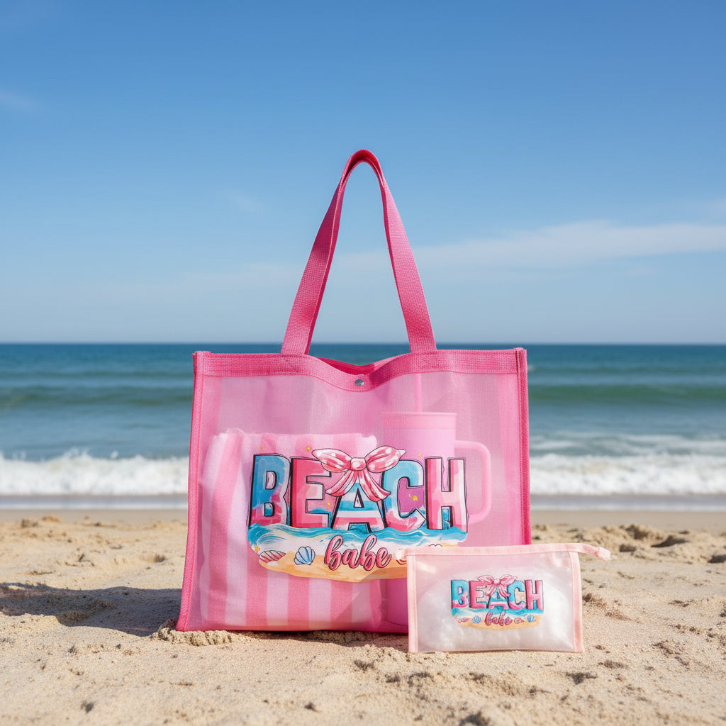 Pink tote bag with 'Beach Babe' design, cup holder, and pouch on a gray surface.