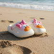 Children's shoes with cartoon face design on a white surface