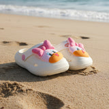 Children's shoes with cartoon face design on a white surface