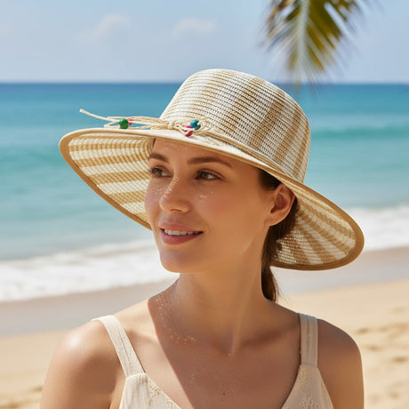 Woman wearing a straw hat on a beach with palm trees and blue sky.