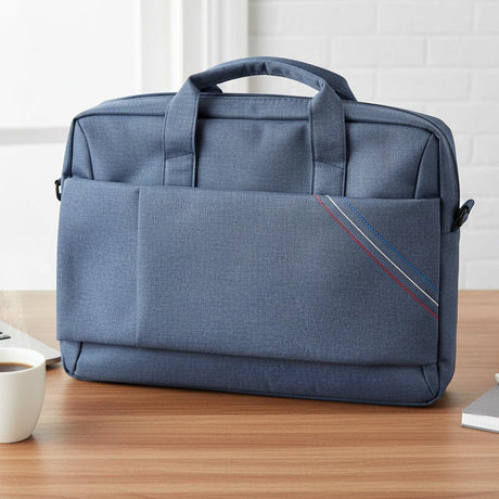 Blue laptop bag on a desk with a laptop, coffee cup, and plant.