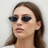 Woman wearing small black sunglasses with a plain background