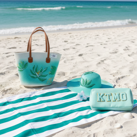 Beach bag, towel, and sunglasses on a sandy beach with ocean view