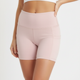 Light pink athletic shorts worn by a person on a white background