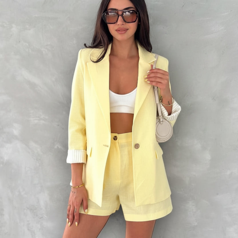 Woman wearing a yellow linen outfit with text detailing item prices on a gray background