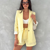 Woman wearing a yellow linen outfit with text detailing item prices on a gray background