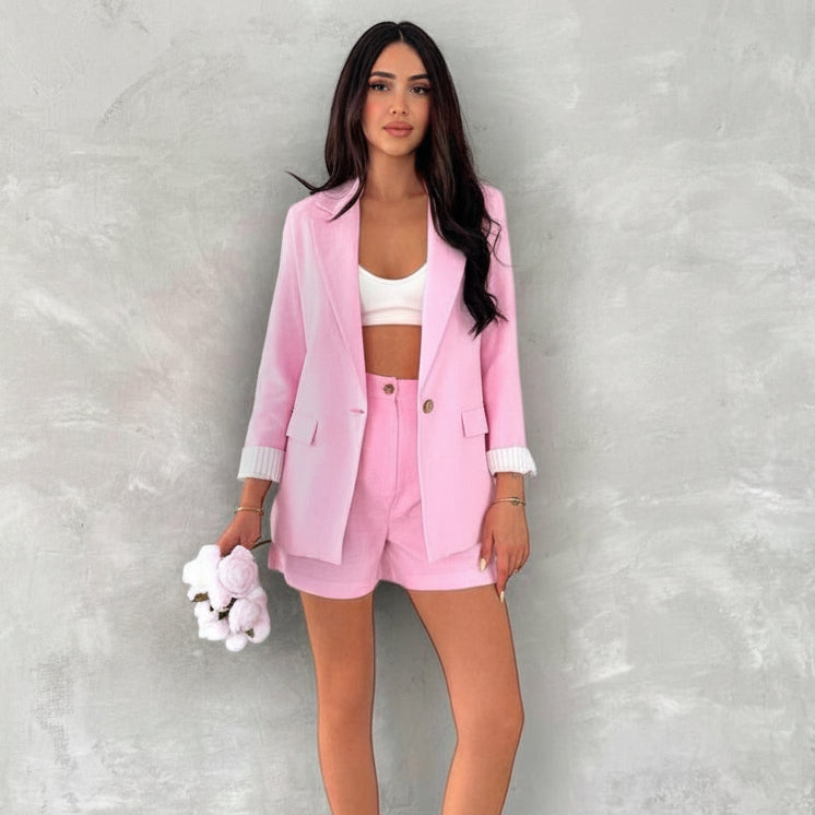 Woman in pink linen outfit with product pricing text on a gray background